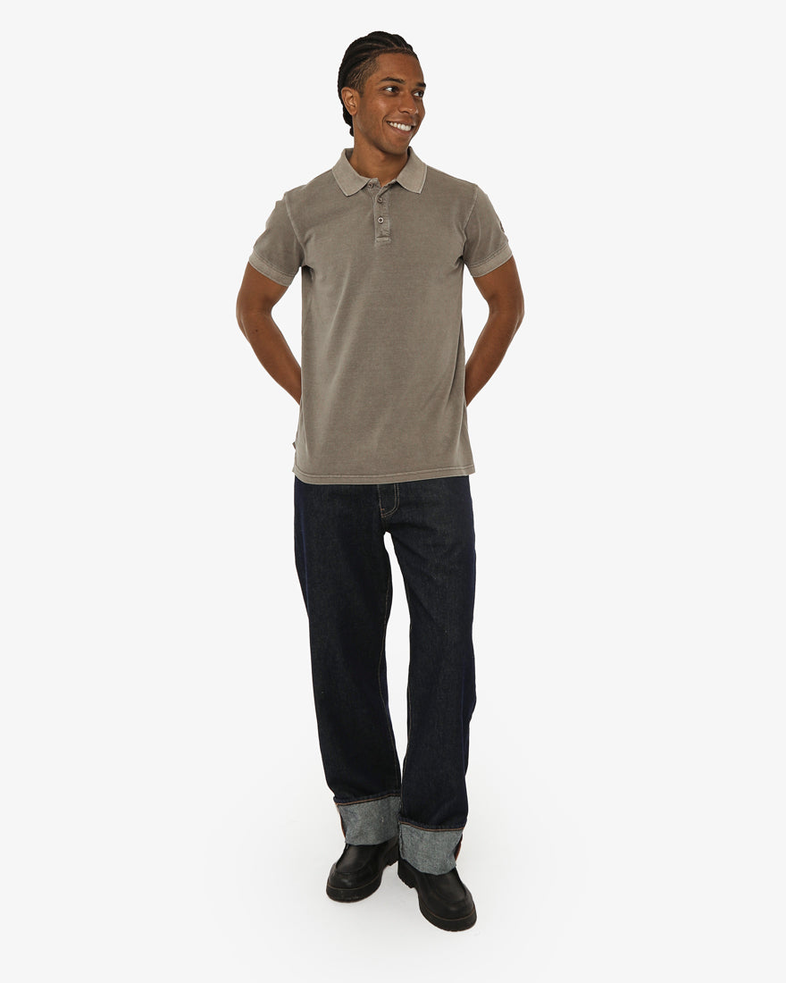 Polo in piquet garment dye, ricamo in tono su manica