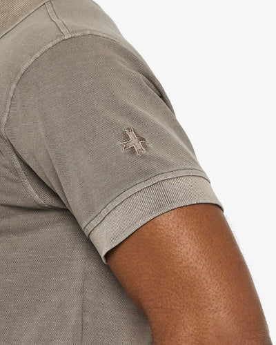 Polo in piquet garment dye, ricamo in tono su manica