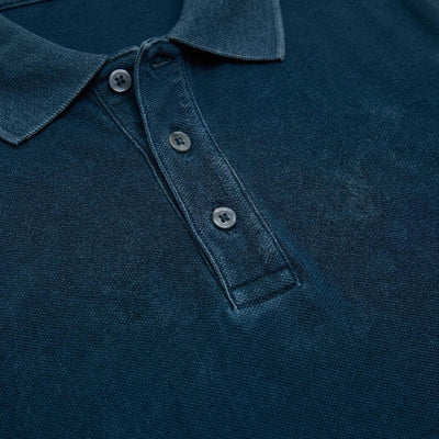 Polo in piquet garment dye, ricamo in tono su manica