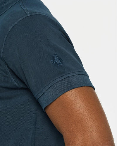 Polo in piquet garment dye, ricamo in tono su manica